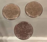 Three identical Jacques Cartier commemorative dollar coins on display