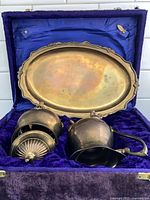Open velvet box showing brass tray, sugar bowl, creamer inside