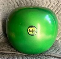 Front view of green ceramic apple with Beatles pin visible