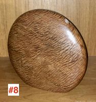 Front view of flattened disc wood vase showing grain patterns and small opening