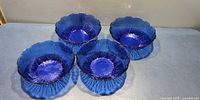 Top view of four cobalt blue pressed glass bowls