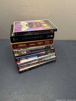 Stack of nine DVD cases on blue surface