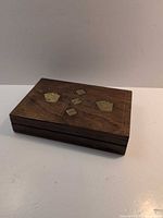 Closed box showing brass inlay gaming motif on lid