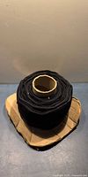 Full view of large roll of black Velcro on cardboard spool