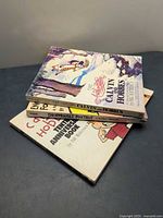 Stack of three comic strip books showing titles and covers
