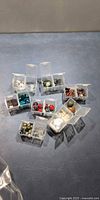 Overview of nine clear plastic bead boxes on tabletop