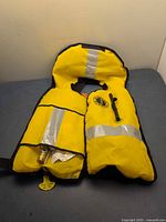 Front view showing yellow exterior, reflective strips, pull tag and CO₂ cylinder