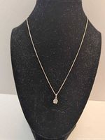 Full view of silver necklace on stand