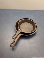 Two nested small cast iron skillets top view