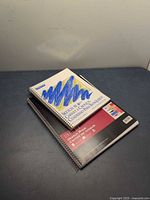 Two spiral sketch books stacked, showing both covers