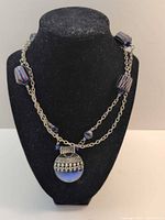 Full view of necklace on bust showing chain, artisan beads and pendant