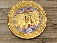 Reverse side of gold-plated commemorative coin showing four portraits and inscriptions