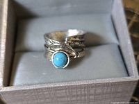 Ring in presentation box showing turquoise cabochon and wrap design