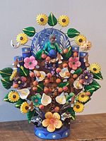 Front view of hand painted Mexican Tree of Life sculpture showing details of flowers, birds, fruit and figure
