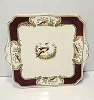 Front view of square Chelsea Bird cake plate showing pattern and gilded rim