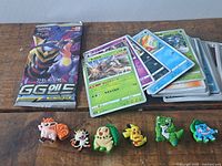 Loose Pokémon cards, sealed booster pack, six Crocs charms front view