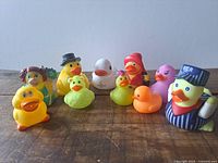 Group shot of ten novelty rubber ducks on wooden surface