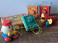 All items grouped: three radios, two pull toys, block puzzle box closed