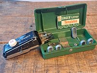 Open case showing buttonholer, templates, feed plate and insert card