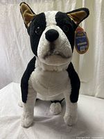 Full view of Melissa & Doug Boston Terrier plush sitting upright with tag