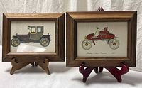 Both framed automobile prints on stands