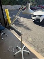 Full view of articulating floor lamp showing shade, arm, and wheeled base