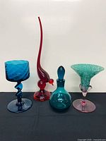 Four art glass pieces standing side by side