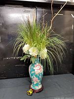Full view of vase on stand with floral arrangement showing scale