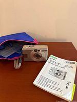 Camera, pouch, manual on table