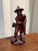 Front view of carved wooden fisherman figurine