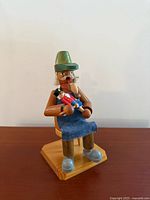 Front view of wood toy maker smoker holding nutcracker
