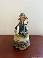 Front view of Hummel girl with accordion and two geese on music box base