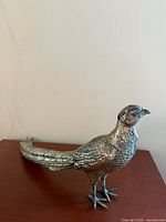 Full side view of one pheasant sculpture showing overall form and finish