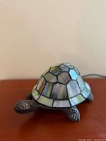 Left side view of turtle lamp showing stained glass shell and metal head