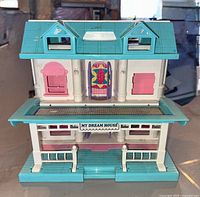 Front exterior view showing teal roof, white walls, porch and sign