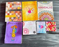 Seven assorted books and notebooks on tabletop