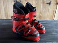 pair of red and black Rossignol Comp J kids ski boots side view