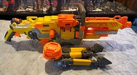 Left side view of Nerf Vulcan EBF-25 with tripod folded beneath and circular accessory attached