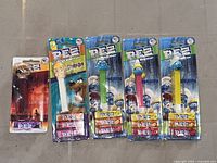 Front view of all five sealed Pez dispensers showing characters and candy rolls