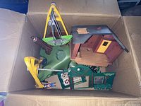 Box containing Playmobil treehouse cabin section, base, crane, bucket, wall panels and accessories
