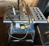 Full view of Ryobi table saw on stand with accessories visible