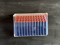 Front view of sealed blister pack showing all blue foam darts with orange tips