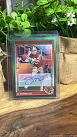 Front view of Joe Montana Score End Zone autograph card in top loader