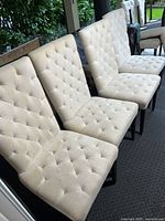 Front view of four tufted dining chairs showing upholstery and tufting