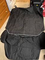 Full view of black car seat cover laid flat