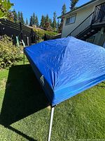 Side view of blue canopy on metal frame in yard