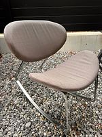 Front angled view showing grey upholstered seat and back with chrome rocker frame