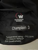 Brand detail on stuff sack showing Outdoor Works Champlain 3 and specs