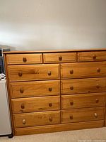 Front view showing all eleven drawers and mix of knobs