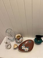 Group view of all items: crystal vase, decanter, Herta ceramics (jug, triangular dish, oblong dish) and Blue Mountain Pottery jug